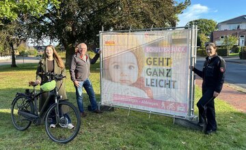 Sophia von der Lieth, Martin Döscher und Birte Heimberg stehen neben einem Banner