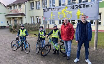 Schüler mit Fahrrädern und Warnwesten vor der Grundschule Neuenwalde