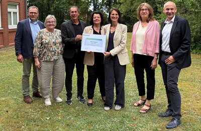 Landwirtschaftsministerin Miriam Staudte überreicht einen Urkunde an u.a. Gabi Kasten und Frank Thielebeule