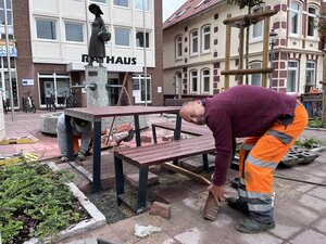 Handwerker stellen Sitzgruppe vor dem Rathaus auf