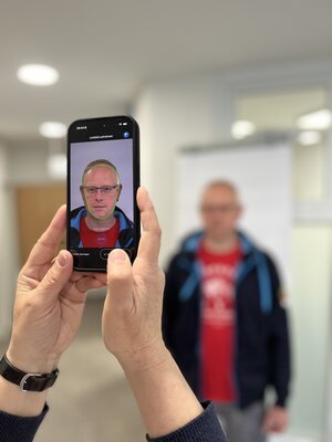 Bürger lässt sich vor weißer Wand fotografieren