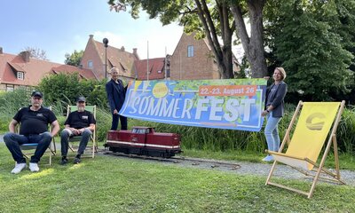 Vertreter der Stadt Geestland, vom Verschönerungsverein und von der Museuumsbahn mit Banner für Sommerfest vor der Burg Bederkesa