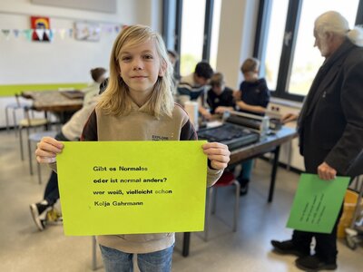 Ein Schüler hält ein Blatt mit seinem Haiku in die Kamera