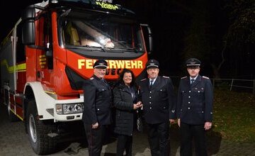 Bürgermeisterin Gabi Kasten übergibt einen Schlüssel an die Feuerwehrkameraden