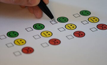 Kugelschreiber malt auf Papier mit bunten Smileys