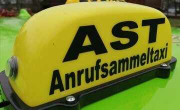 Gelbes Schild mit der Aufschrift Anrufsammeltaxi