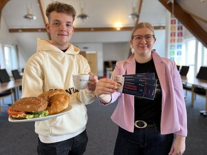 Auszubildende mit Brötchen und Eintrittskarten in den Händen