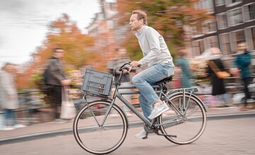 Mann fährt auf Fahrrad durch die Stadt