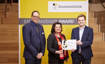 Staatsanzeiger-Chefredakteur Rafael Binkowski (von links) gratuliert Geestlands B¸rgermeisterin Gabi Kasten und Pressesprecher Merlin Hinkelmann zur Auszeichnung.
