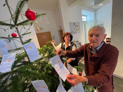 Ellen und Wolfgang Liedtke vom Tafel-Team befestigen die Wünsche am Tannenbaum