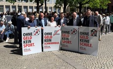 Bürgermeister mit Protestschildern vor dem Landtag