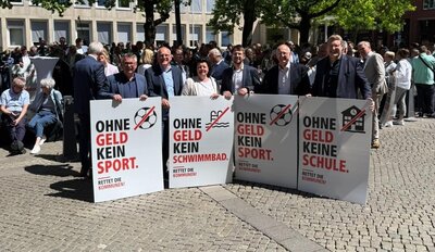 Bürgermeister mit Protestschildern vor dem Landtag