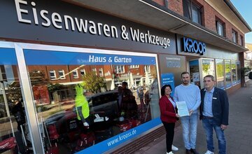 Bürgermeisterin Gabi Kasten (links) und Mark Saydak vom Landkreis Cuxhaven überreichen den Förderbescheid an Krooß-Geschäftsführer Kai Weber. 
