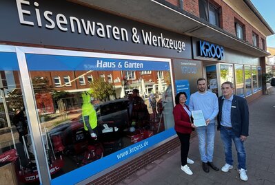 Bürgermeisterin Gabi Kasten (links) und Mark Saydak vom Landkreis Cuxhaven überreichen den Förderbescheid an Krooß-Geschäftsführer Kai Weber. 
