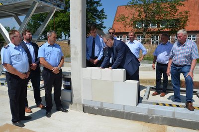 Bürgermeister Thorsten Krüger lässt die Zeitkapsel im Grundstein versinken