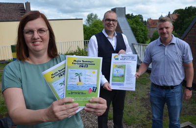Mareike Buck, Bürgermeister Thorsten Krüger und Dennis Rösner präsentieren das Sommerferienprogramm