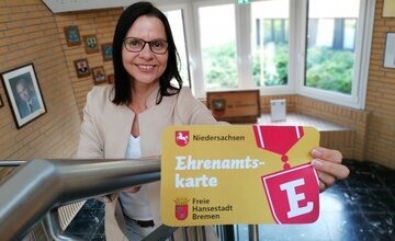 Sonja Thomas hält eine Ehrenamtskarte in der Hand
