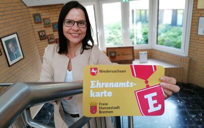 Sonja Thomas hält eine Ehrenamtskarte in der Hand