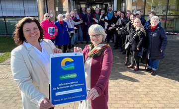 Bürgermeisterin Gabi Kasten und Gleichstellungsbeauftragte Sabine Wohlers stehen mit Plakat vor dem Langener Rathaus