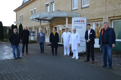 Vertreter von Ameos und der Stadt Geestland stehen vor dem Ameos-Klinikum Debstedt