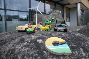 Playmobil-Autos stehen auf einem Stein