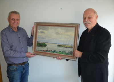 Frank Hansen und Uwe Bischoff hängen das Bild im Rathaus auf