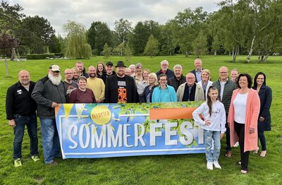 Organisatoren mit Banner im Kurpark