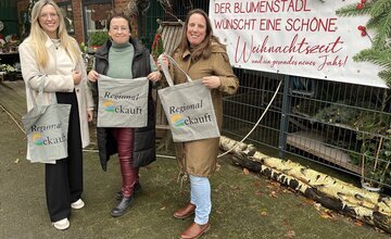 Wirtschaftsförderin Katja Beier und Klimaschutzmanagerin Katharina Koop mit Bärbel Pape vor ihrem Blumengeschäft in Kührstedt