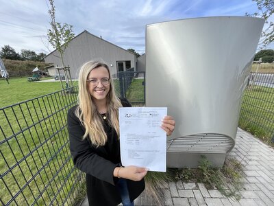 Klimaschutzmanagerin Katharina Koop hält den Förderbescheid in den Händen